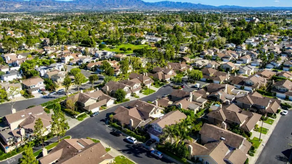 Aerial view of an established East Murrieta neighborhood with tile-roof homes and mountains beyond, Murrieta, California